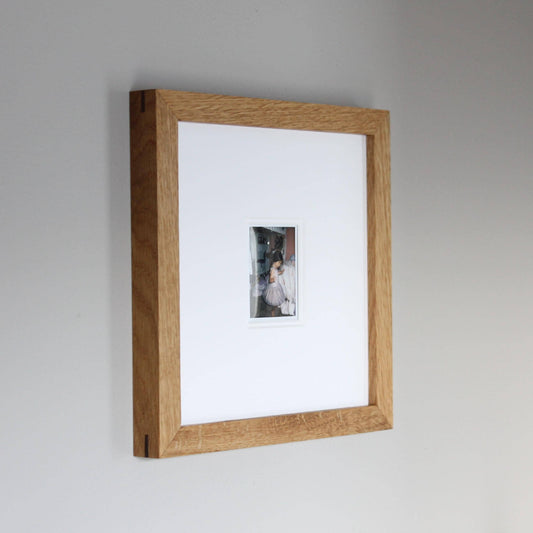 a picture hanging on a wall with a wooden frame