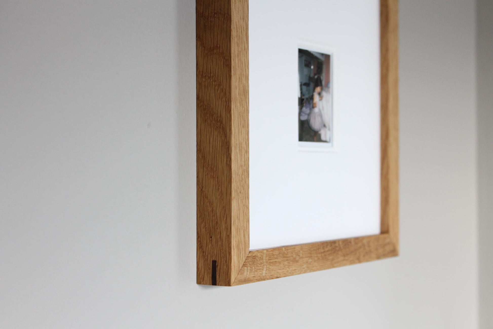 a picture hanging on a wall with a wooden frame