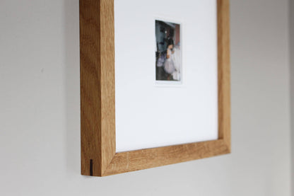 a picture hanging on a wall with a wooden frame