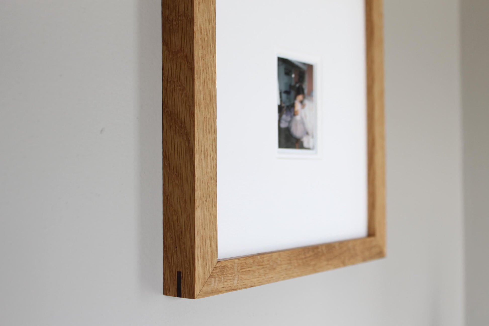 a picture hanging on a wall with a wooden frame