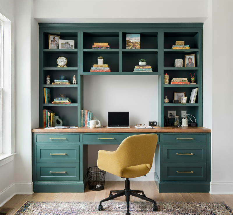 Home office with teal bookshelves and desk, yellow chair, and various items.